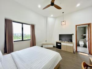 a bedroom with a bed and a flat screen tv at Soleil Crown Boutique in Thôn Trường Giang