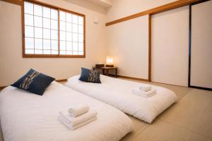 two white beds in a room with a window at nozawasnow in Nozawa Onsen