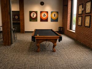 a pool table in the middle of a room at Brick & Bed Riverfront Lofts, T 303 in Saint Louis