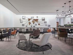 a waiting room with chairs and a table at Hotel Mondial am Dom Cologne MGallery in Cologne