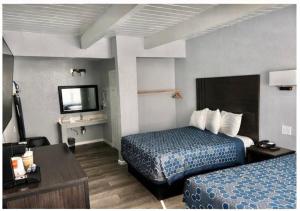 a hotel room with two beds and a television at Sea Garden Inn Pismo Beach- San Luis Obispo in Pismo Beach +46 photos