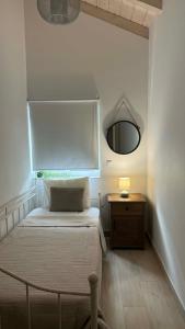 a bedroom with a bed with a mirror and a table at Mama’s house in Ágios Rókkos