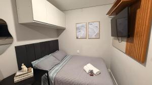 a small bedroom with a bed and a tv at LOFT 02 · Loft127-02 Compacto, equipado, ótima localização in Itajaí