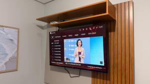a flat screen tv hanging on a wall at LOFT 02 · Loft127-02 Compacto, equipado, ótima localização in Itajaí