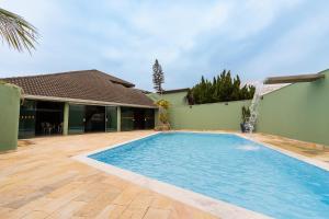 a swimming pool in front of a house at Casa de praia Peruibe in Peruíbe