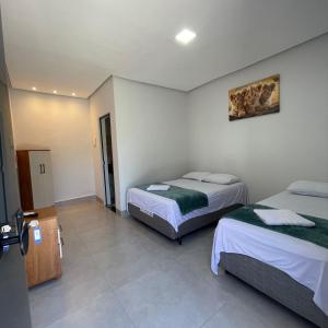 a room with two beds in a room with at Hotel Iluminar in Goianésia