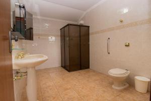 a bathroom with a shower and a toilet and a sink at Casa de praia Peruibe in Peruíbe +16 photos