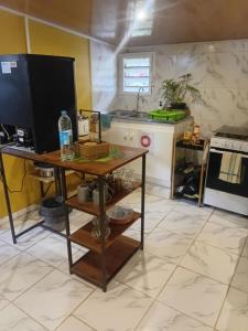 a kitchen with a table with a television and a counter at Tereva home 1 in Bora Bora