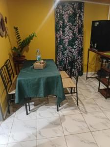 a table and chairs with a green table cloth on it at Tereva home 1 in Bora Bora