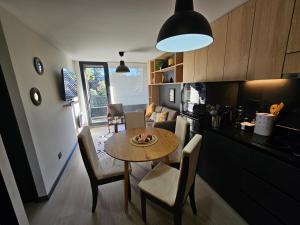 a kitchen and dining room with a table and chairs at Depto con Piscina Temperada 2D y 2B in Puerto Varas