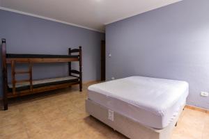 a bedroom with a bed and a bunk bed at Casa de praia Peruibe in Peruíbe