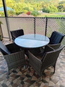 a glass table and chairs on a patio at Tereva home 2 in Bora Bora