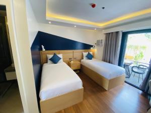 a hotel room with two beds and a balcony at Wyndale Hotel in Camalig