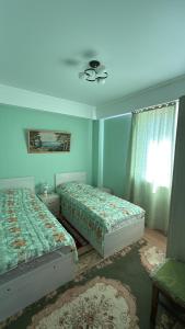 a bedroom with two beds and a window at Берег in Bosteri