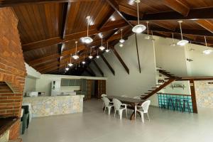 a dining room with a table and chairs and a staircase at Casa de praia Peruibe in Peruíbe