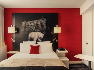 a bedroom with a red and black wall with a bed at Mercure Paris Opera Louvre in Paris