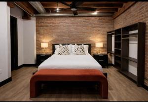 a bedroom with a large bed and a brick wall at Brick & Bed Riverfront Lofts, T 308 in Saint Louis