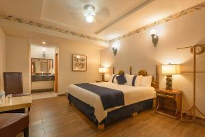 a hotel room with a bed and a television at Hotel Boutique Grand Mayes in Pátzcuaro