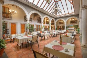 a restaurant with tables and chairs and a large ceiling at Hotel Boutique Grand Mayes in Pátzcuaro
