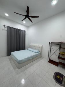 a bedroom with a bed and a ceiling fan at Dgajah Homestay in Batu Gajah