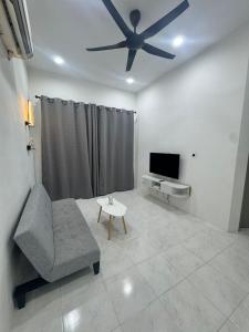 a living room with a couch and a ceiling fan at Dgajah Homestay in Batu Gajah