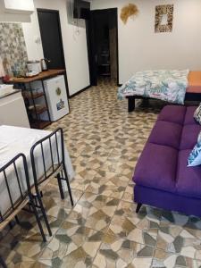 a living room with a purple couch and a kitchen at Tereva home 2 in Bora Bora