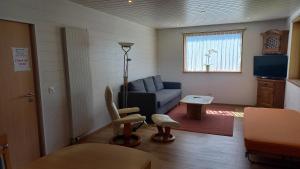ein Wohnzimmer mit einer blauen Couch und einem Fenster in der Unterkunft Panoramaplatz in Ried-Brig