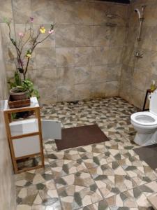a bathroom with a toilet and a tiled floor at Tereva home 2 in Bora Bora