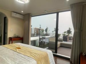 a bedroom with a bed and a large window at Châu Anh House in Ðố Sơn