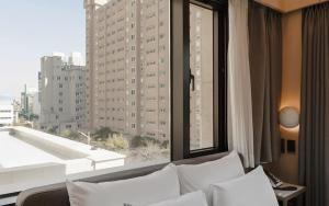 a living room with a couch and a large window at Browndot Hotel Mokpo Gotbawi in Mokpo