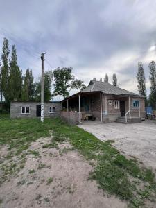 a small brick house in a field next to a yard at Satina Jenish in Syn-Tash
