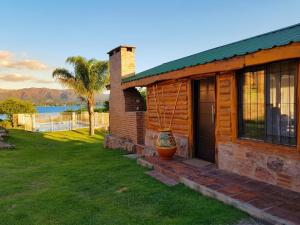 a log cabin with a porch and a door at Cabañas Lago Azul in Villa Santa Cruz del Lago
