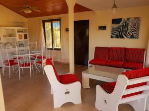 a living room with red and white chairs and a table at Cabañas Lago Azul in Villa Santa Cruz del Lago +4 photos