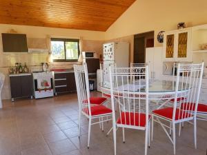 a kitchen with a table and chairs in a room at Cabañas Lago Azul in Villa Santa Cruz del Lago
