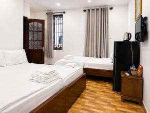 a hotel room with two beds and a television at Khách sạn Phương Danh in Phú Tài (1)