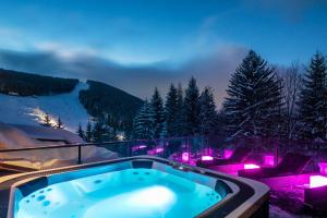 a jacuzzi tub on the balcony of a resort at Pytloun Wellness Hotel Harrachov in Harrachov