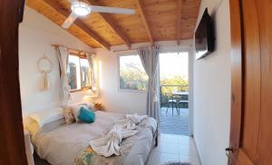 a bedroom with a bed in a room with a balcony at Altos del Pucara Piscina Climatizada vista a las sierras juegos Huerta Orgánica in Huerta Grande