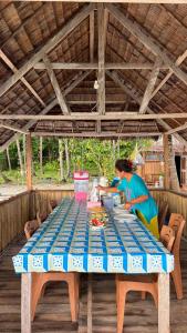 a woman preparing food at a table on a deck at Saubaryam Home stay in Fam +42 photos