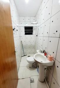 a white bathroom with a toilet and a sink at Hospedagem Aeroporto in Campinas