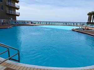 a large blue swimming pool with the beach in the background at Golden Hour Penthouse - TideWater Beach Resort 2700 in Panama City Beach