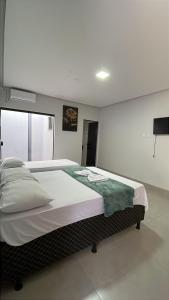 a bedroom with a large bed in a room at Hotel Iluminar in Goianésia