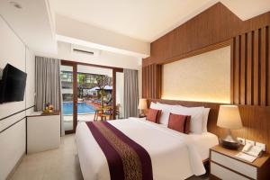 a hotel room with a bed and a television at Nadi Hotel Legian in Legian +46 photos