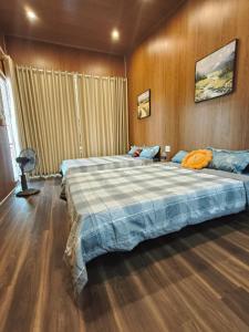 a bedroom with two beds and a wooden wall at H Vy Homestay in Phương Phi