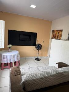 a living room with a couch and a flat screen tv at Sol e mar in Serra