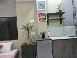 a kitchen with a white refrigerator and a sink at Bống's Homesray and café in Ho Chi Minh City
