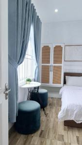a bedroom with a bed and a table and a window at Khách Sạn Lý Sơn Phú Sỹ in Ly Son