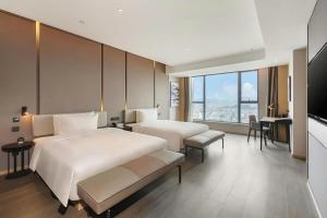 a hotel room with two beds and a television at 东莞凤岗南天大厦亚朵酒店 in Qinglinjing +63 photos