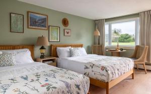 a bedroom with two beds and a window at Gale River House - Boutique Hotel in Franconia