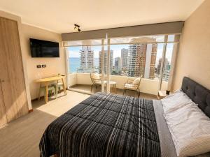 a bedroom with a large bed and a large window at Estudio peninsula Cavancha in Iquique