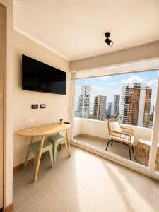a living room with a table and a large window at Estudio peninsula Cavancha in Iquique